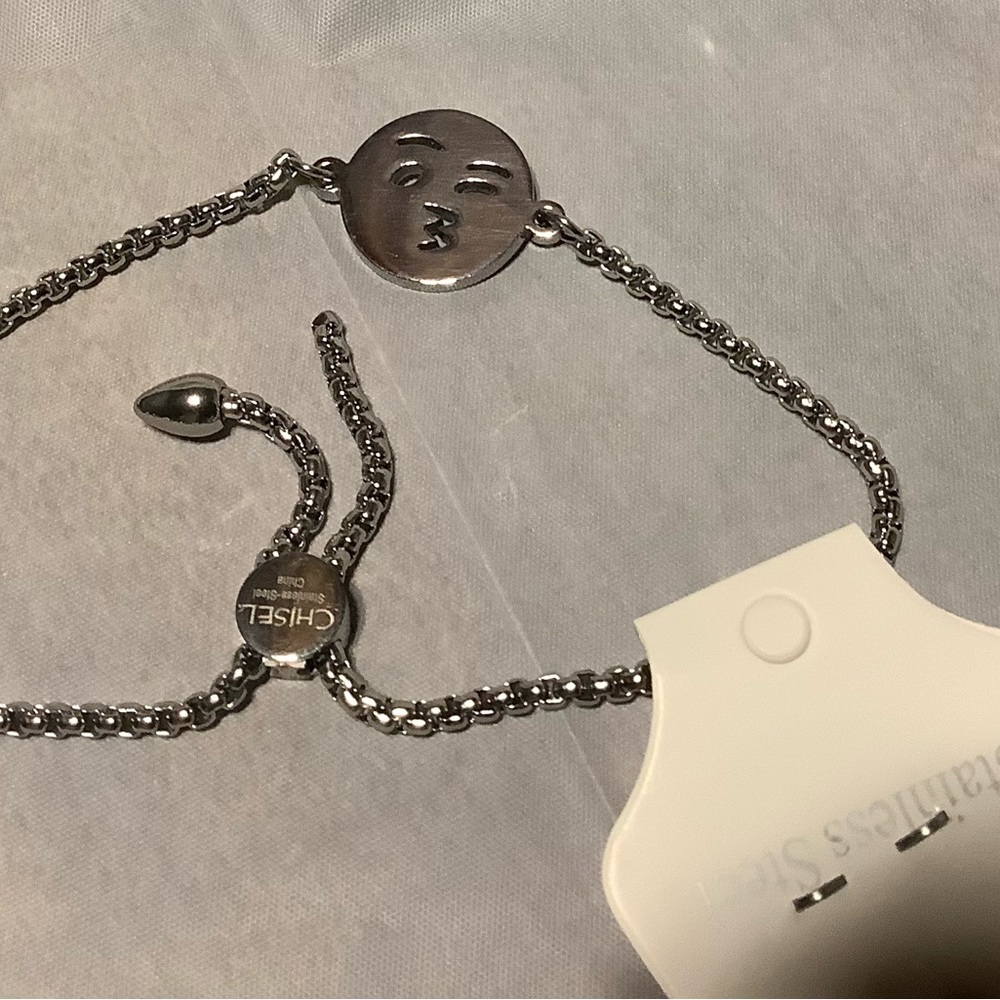 Emoji bracelet of stainless steel. The adjustable bracelet fits large wrists.